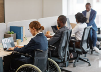 Woman In Wheelchair Working With Colleagues